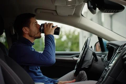 Man drinking coffee while sitting in car Stock Photos