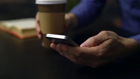 Man drinking coffee while using a phone Stock Footage 85447668