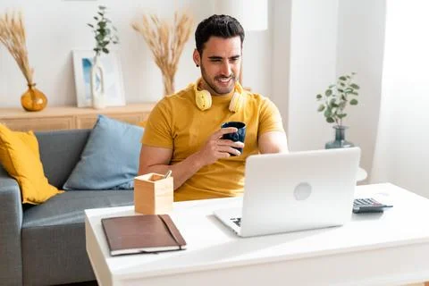 Man drinking coffee while working at home. Stock Photos