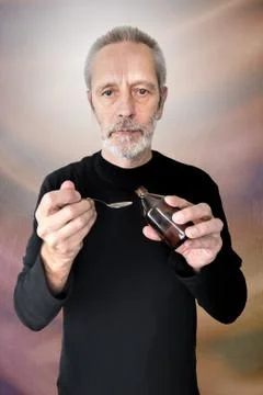 Man Drinking Cough Syrup Stock-Fotos