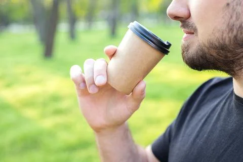 A man drinking from a craft cup close-up in the park Stock-Fotos