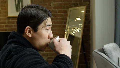 Man drinking cup of coffee in living room at home Stock Footage 111967351