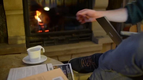 A Man drinking a Cup of Coffee near Fireplace in a Living Room Stock Footage 84385381