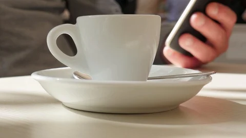 Man drinking a cup of coffee while checking his phone Stock Footage 125552445