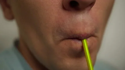 Man drinking a drink from a plastic cocktail tube, close up Stock Footage 141078487