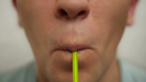Man drinking a drink from a plastic cocktail tube, close-up Stock Footage 141808109