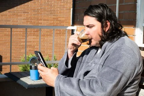 Man drinking espresso and texting on smartphone in bathrobe Stock Photos