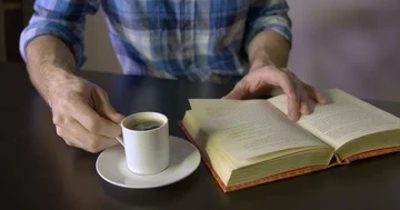 Man drinking espresso while reading Stock Footage 85421452
