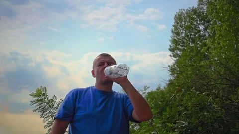 Man is drinking fresh water from a plastic bottle Stock Footage 81171688