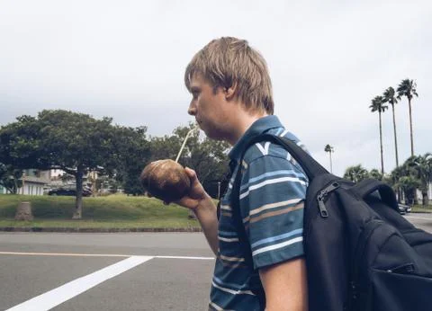 Man is drinking freshly opened coconut juice at tropical island Stock Photos
