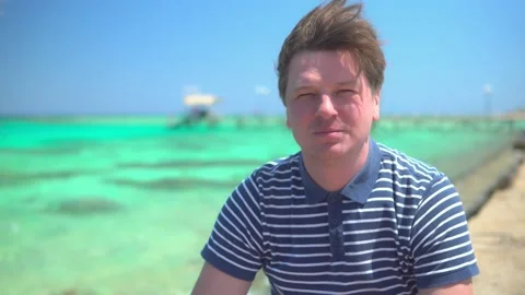 Man drinking fruit cocktail by the azure sea Stock Footage 152858978