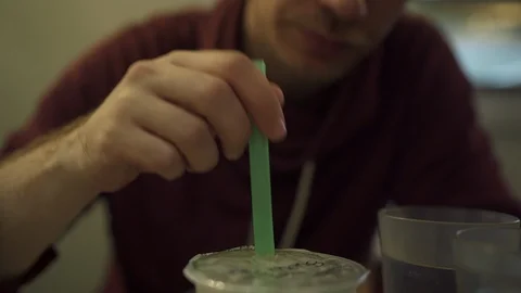 Man is drinking a funny cocktail in a Chinese restaurant 库存影片 109488984