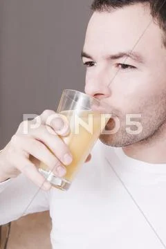 Man Drinking A Glass Of Fresh Orange Juice, Portrait, Close-Up