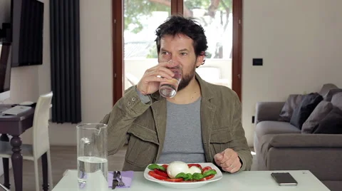 Man drinking glass of water ready for lunch at home Stock Footage 59824055
