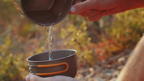 Man drinking hot tea in camping, mate Tea Preparation at the Campsite Amidst the Video stock 285433437