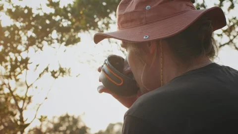 Man drinking hot tea in camping, mate Tea Preparation at the Campsite Amidst the Stock Footage 285433468