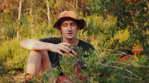 Man drinking hot tea in camping, mate Tea Preparation at the Campsite Amidst the Stock Footage 289669762