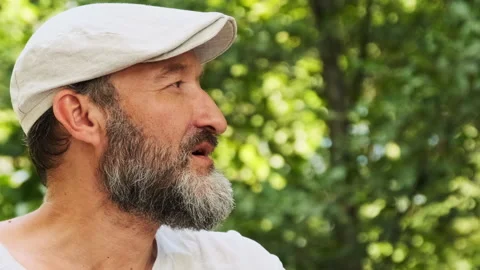 A man is drinking hot tea by the fire in the forest. In summer, a person look Video stock 148338903