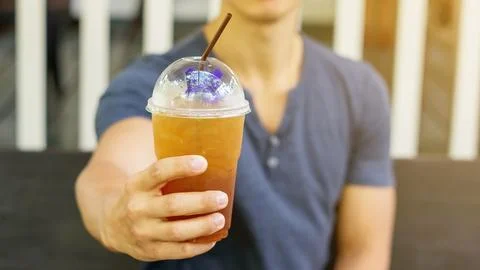 Man drinking an iced fruit tea in a cafe. Foto stock