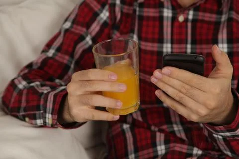 Man drinking a juice and checking his phone Stock Photos