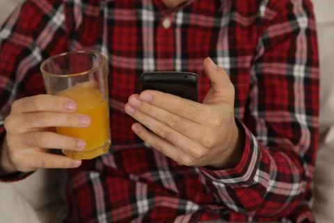 Man drinking a juice and checking his phone Stock-Fotos