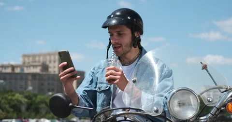 Man drinking juice and using mobile phone on motorcycle Stock Footage 136357190