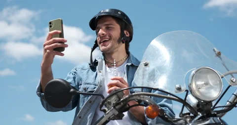 Man drinking juice and using mobile phone on motorcycle Stock Footage 136357921