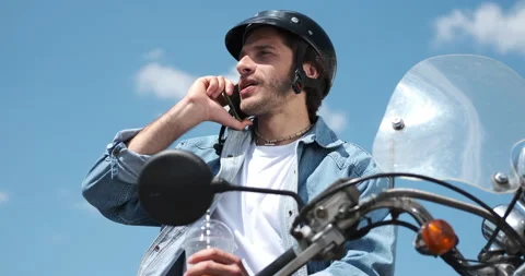 Man drinking juice and using mobile phone on motorcycle Stock Footage 136358811