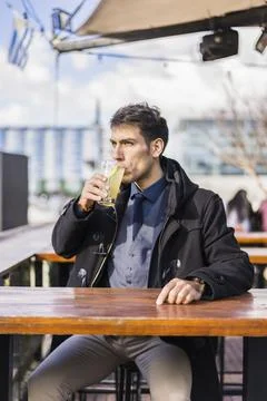 Man drinking a lemonade while sitting in a bar at the harbor Foto stock