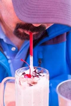 Man drinking a milkshake through a straw Stock Photos