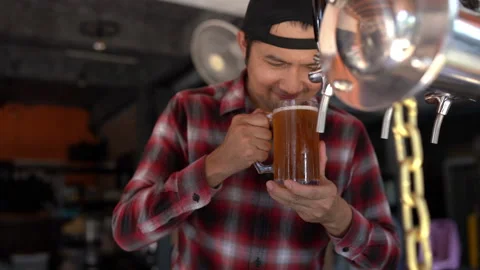A man is drinking from a mug with a chain hanging from it Stock Footage 279627694