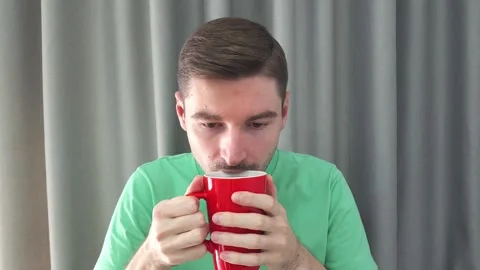 Man drinking from a red mug. Man Sipping from a Cup. Stock Footage 284042729