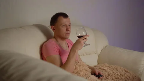 Man drinking red wine and watching tv in the evening Stock Footage 139640751
