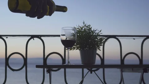 A man drinking red wine on the balcony on the background of the sea. Close-up. Stock Footage 87499033