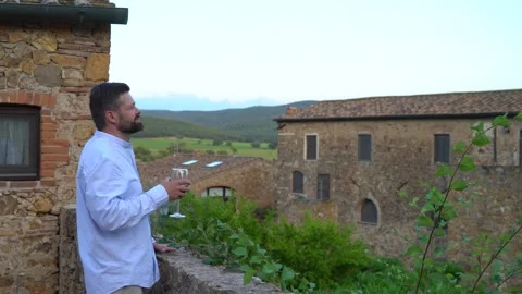 Man drinking red wine in the patio of an old Italian villa Stock Footage 244812515