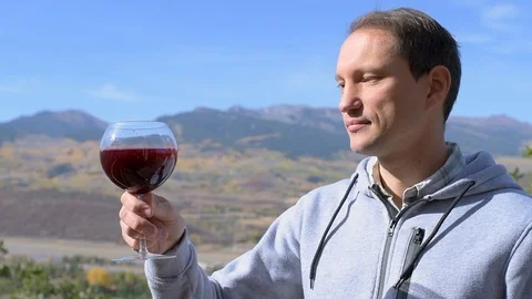Man drinking red wine with view of rocky mountains in Aspen, Colorado slowmo Stock Footage 120608119