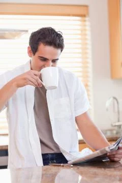 Man drinking some coffee while reading the newspaper Stock Photos