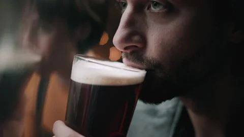 Man drinking stout beer next to a woman in a pub Stock Footage 132017031
