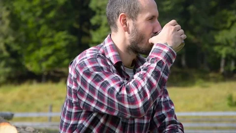 Man drinking tea on chopped wood Stock Footage 82700611