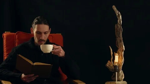 Man drinking tea next to the lamp Stock Footage 99962994
