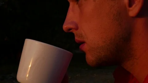 A man is drinking tea or coffee at sunset. HD, 1920x1080. slow motion. Stock Footage 80859114