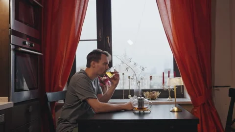 Man drinking tea at a table by the window Stock Footage 295171439