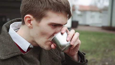 The man is drinking tea from the thermos, smiling, looking at the woman. Cold Stock Footage 73859500