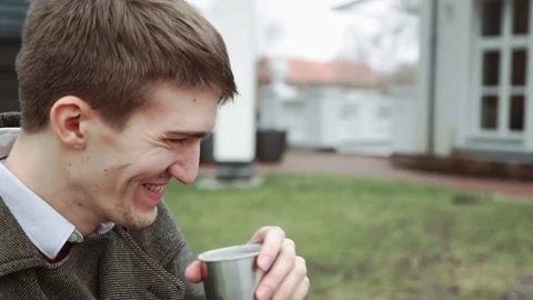 The man is drinking tea from the thermos, smiling, looking at the woman. Cold Stock Footage 73860169