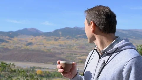 Man drinking tea with view of rocky mountains in Aspen, Colorado slowmo Stock Footage 120608096