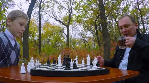 A man drinking tea while playing chess in the park. Close-up. Stock-Footage 56312225