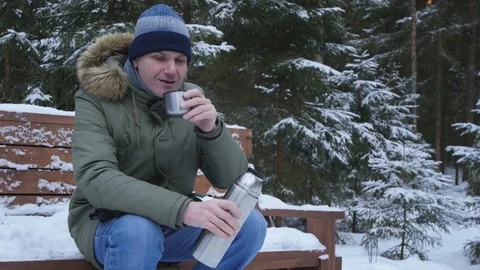 Man drinking tea in winter forest Stock Footage 76999391