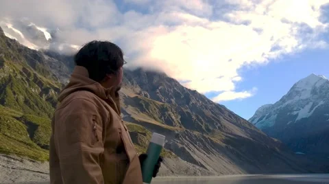 Man Drinking From Thermos While Enjoying Mountain  Scenery Video stock 64176321