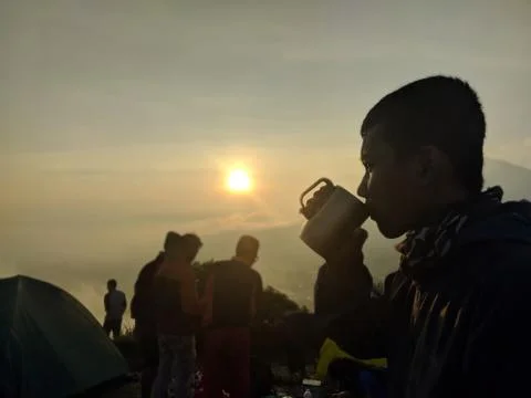A man drinking in the top mountain Stock Photos