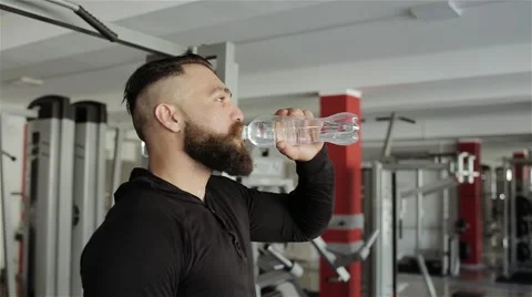 Man drinking water after workout in the gym Stock Footage 56636640